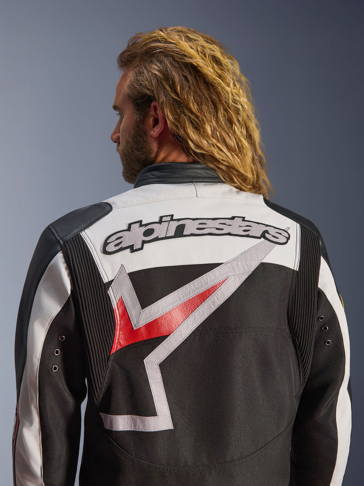 Alpinestars Axton Jacket, Motorcycle Jacket, Black Off White and Bright Red, rear view featuring large embroidered Alpinestars logo and stylized graphic, accordion shoulder panels for mobility, vintage-inspired design with metal eyelet details