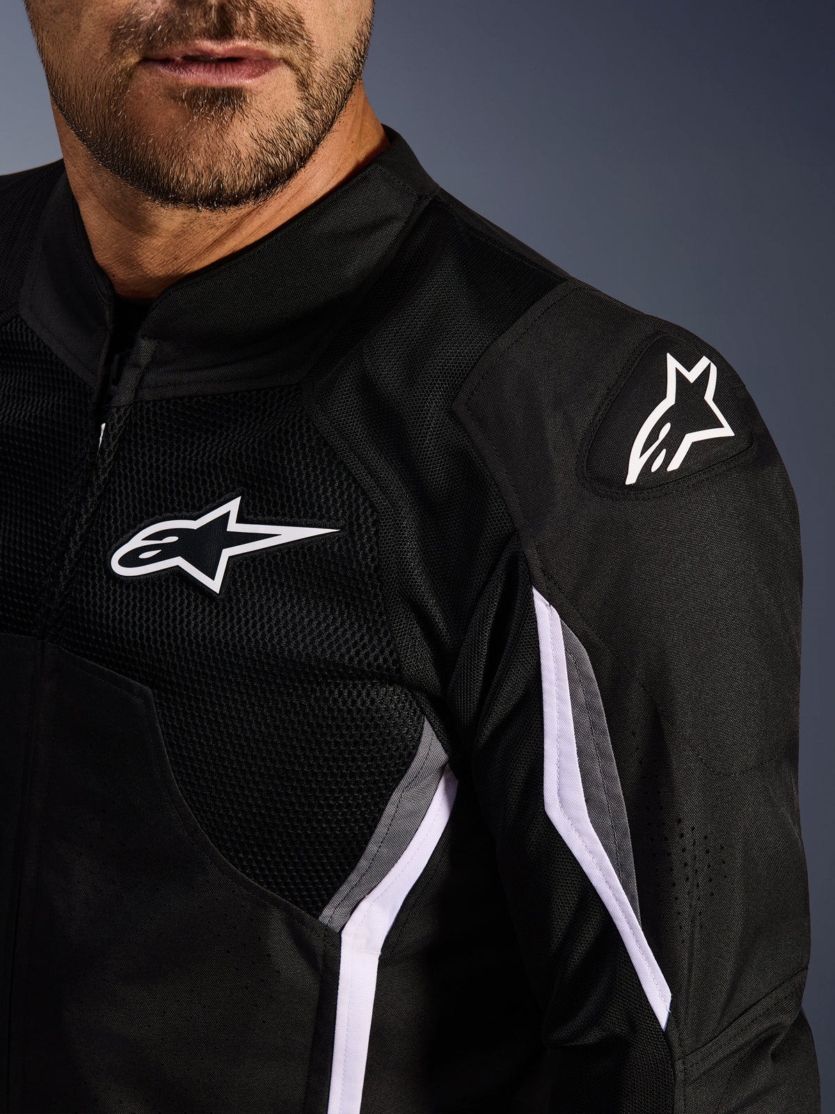 Alpinestars AST V3 Air Jakke, tekstil motorcykeljakke, sort mørkegrå hvid, nærbillede med mesh-paneler, hvidt Alpinestars-logo på bryst og skulder og DFS GP Lite Evo eksterne skulderslidere