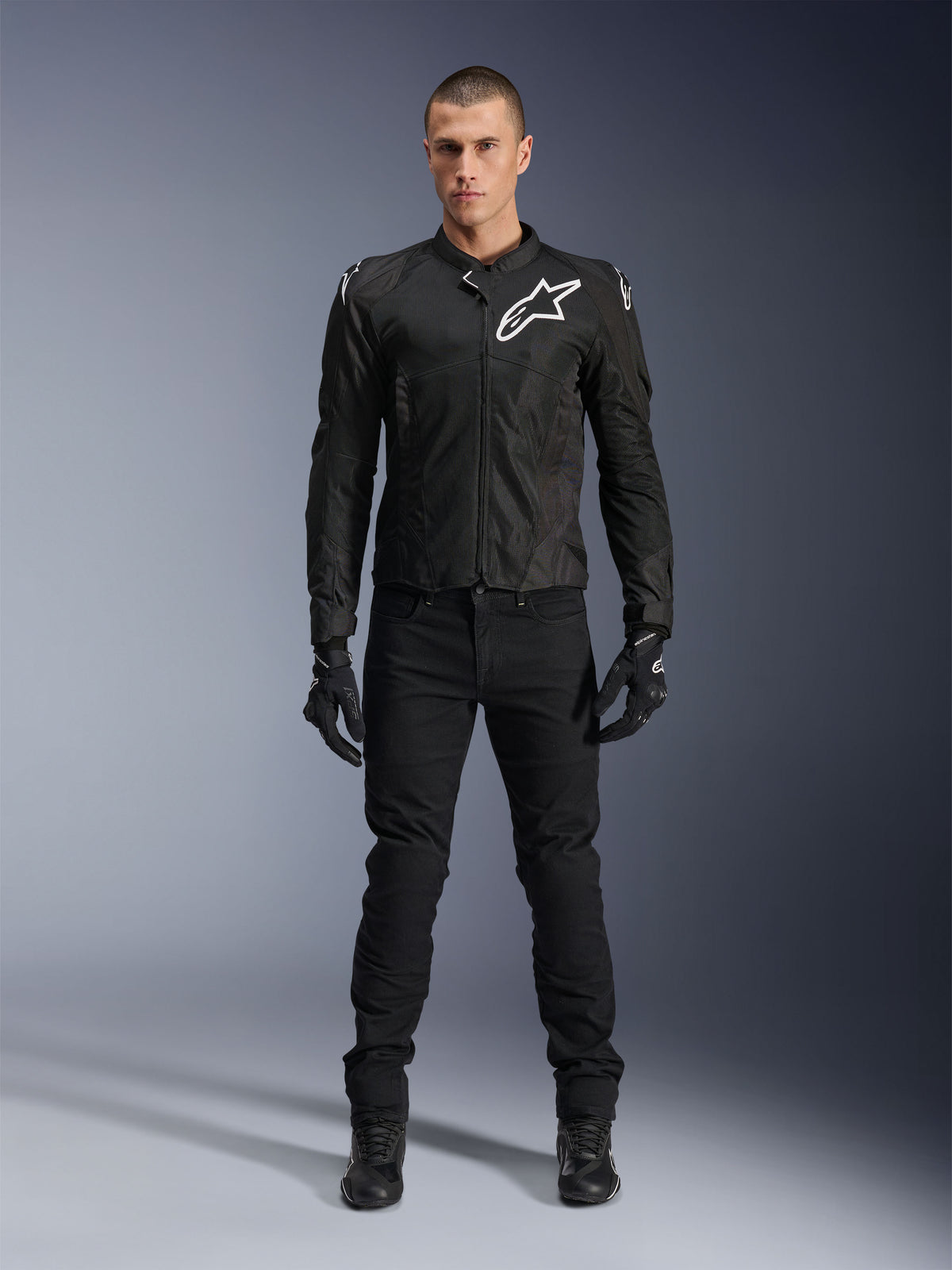 Alpinestars Viper Air V4 Jacket, Black textile motorcycle jacket, white logo on chest and shoulders, worn with black riding pants and gloves, features tech mesh panels for airflow, full-body studio view