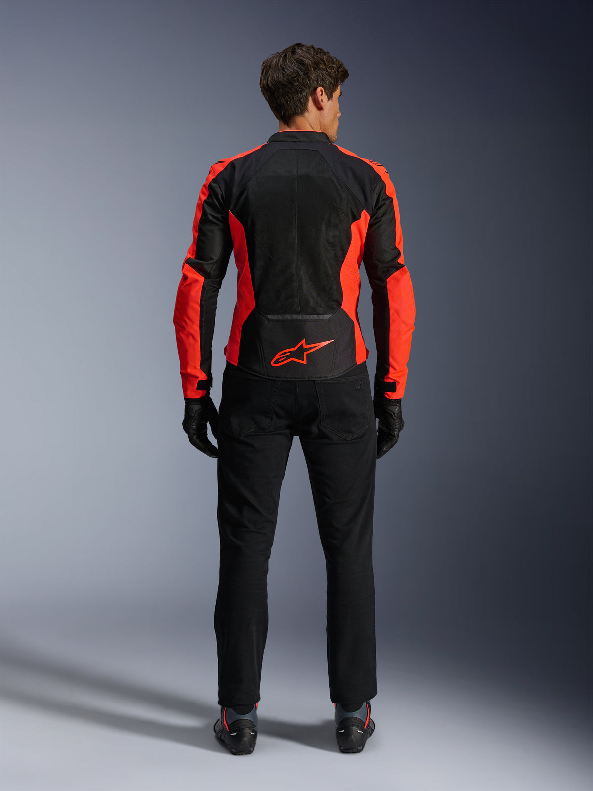 Alpinestars Viper Air V4 Jakke, rød fluo og sort, set bagfra med store tekniske mesh-paneler og klare fluorescerende røde side-accenter, rødt Alpinestars-logo på den nederste del af ryggen, båret med sorte kørebukser og handsker