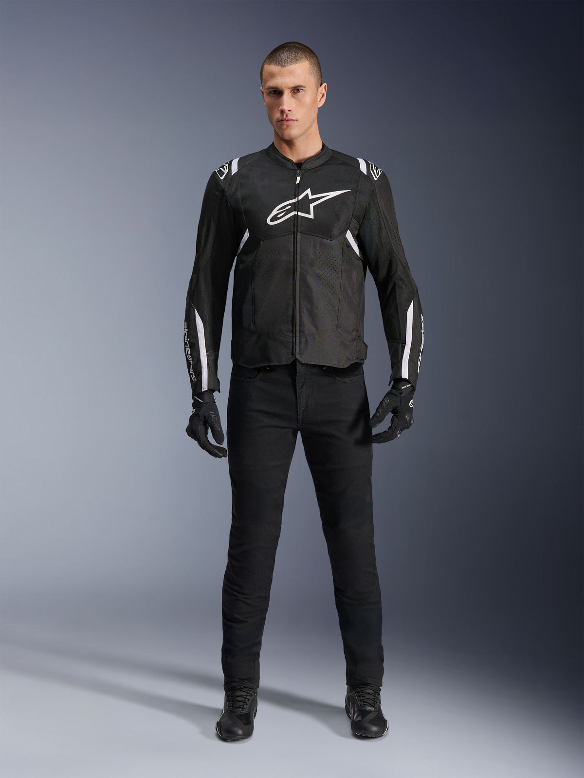 Alpinestars T-Sps Air V2 Jacket, Black and White textile motorcycle jacket, featuring large white chest logo and mesh paneling, worn by a model with black gear for urban sport riding