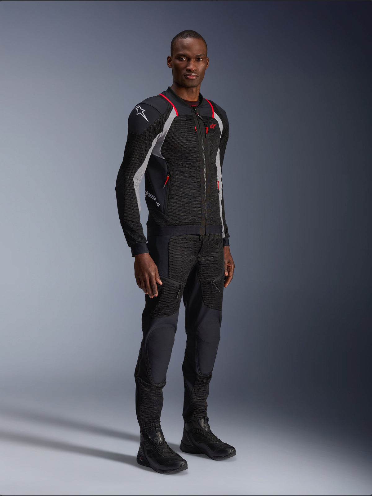 Alpinestars Troop-Air Pro Jacket, Black Ash Gray and Bright Red, technical mesh armored jacket, featuring red accents and white logo on shoulder, worn with matching black pants and boots, modern urban motorcycle apparel