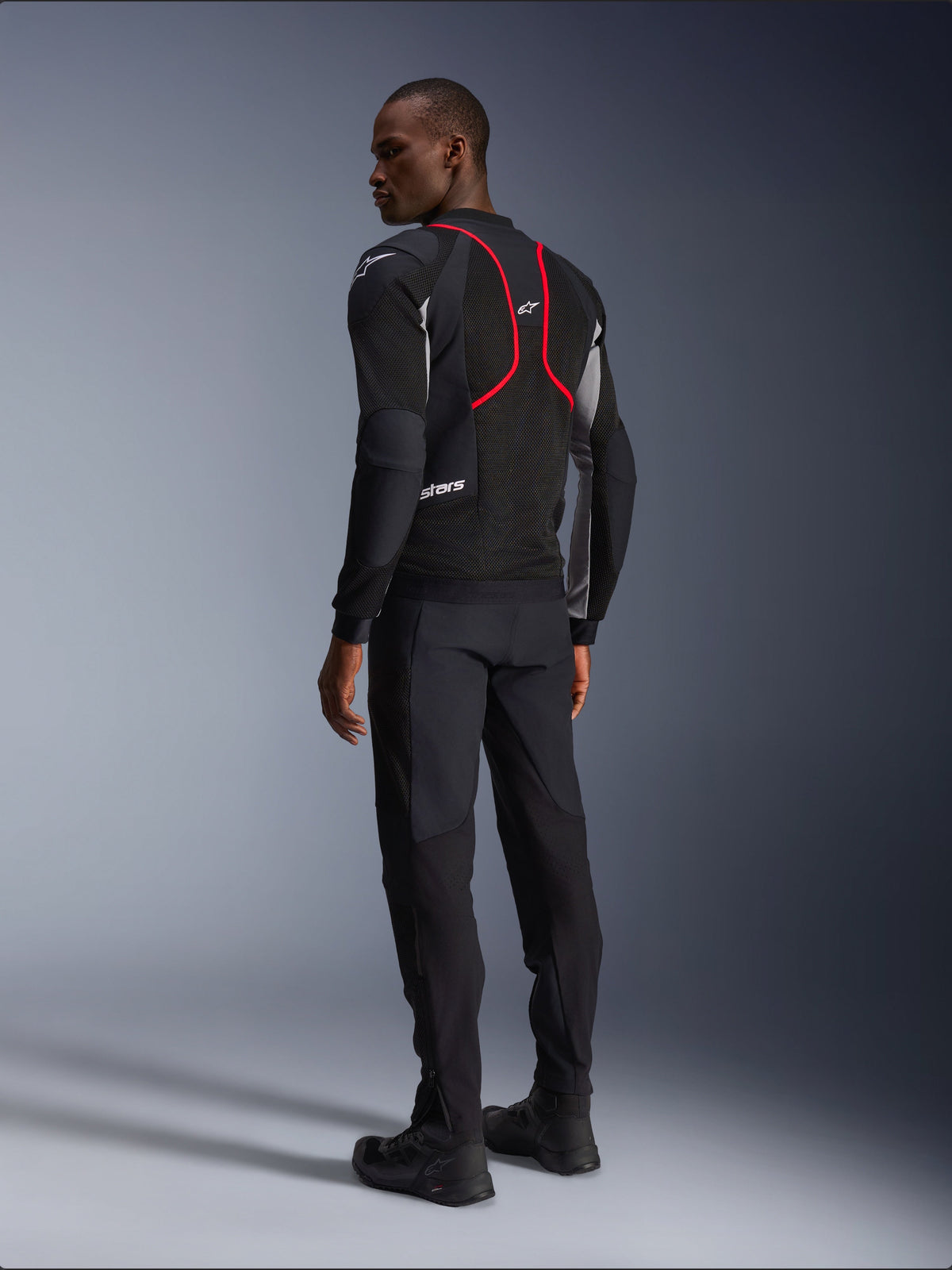 Alpinestars Troop-Air Pro Jacket, Motorcycle Jacket, Black Ash Gray and Bright Red, back view on model, featuring red accent lines and mesh ventilation panels, worn with black pants and boots, urban motorcycle style