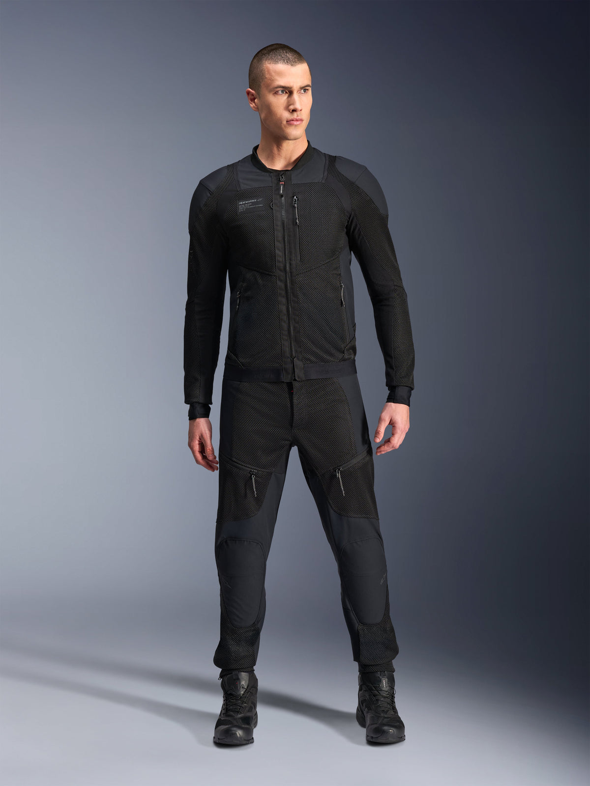 Alpinestars Troop-Air Pro Jakke, sort teknisk pansret motorcykeljakke, med mesh-paneler og lynlåse foran, båret med matchende sorte bukser og motorcykelstøvler, premium urbant køreudstyr