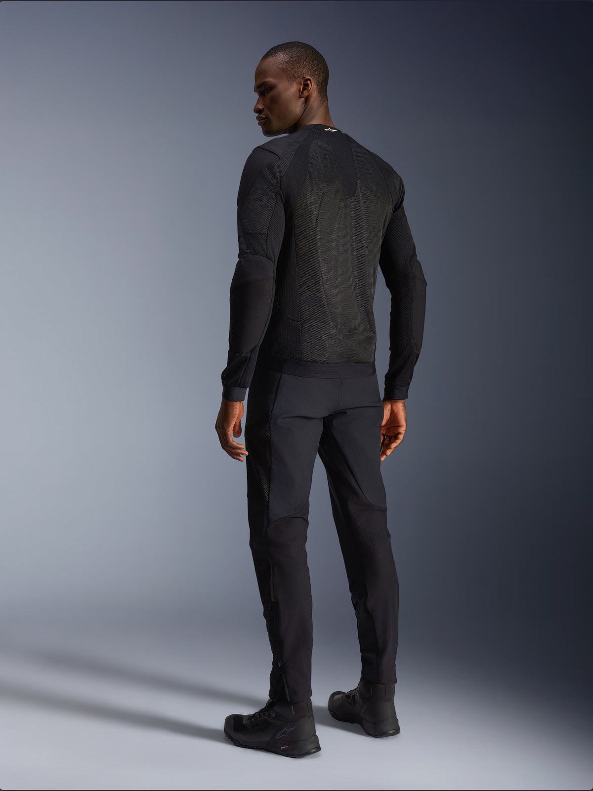 Alpinestars Troop-Air Jakke, sort urban mesh-motorcykeljakke set bagfra på model med store ventilationspaneler.