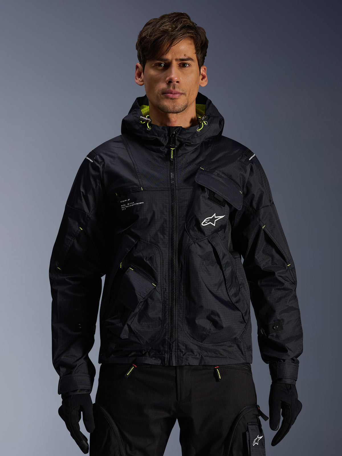 Alpinestars Mogress Air jakke, urban motorcykeljakke til mænd, sort og Lime Punch, med utility-hætte, båret af model.