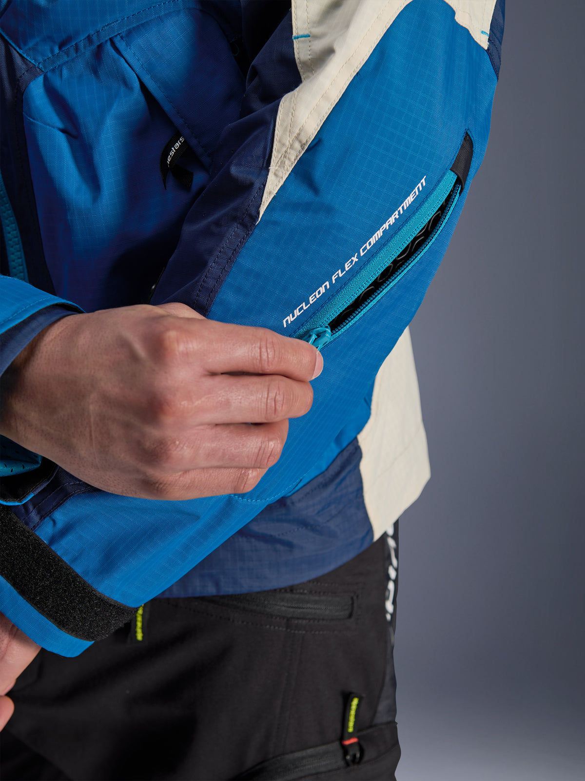 Alpinestars Mogress Air jakke, urban motorcykeljakke i blå og beige, med et lynlåslukket Nucleon Flex-beskytterrum på ærmet.