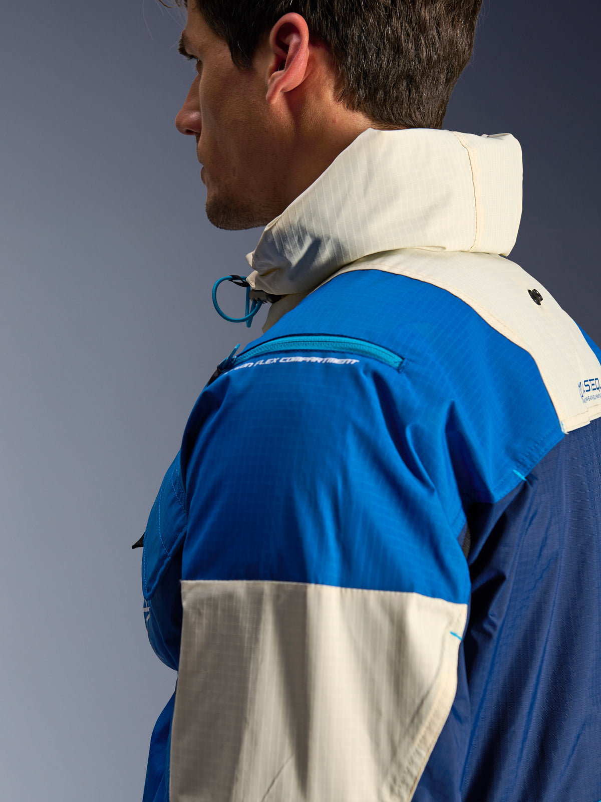 Alpinestars Mogress Air jakke, urban herre-motorcykeljakke, blå og creme, genanvendt ripstop med høj krave og hætte, sideprofil.
