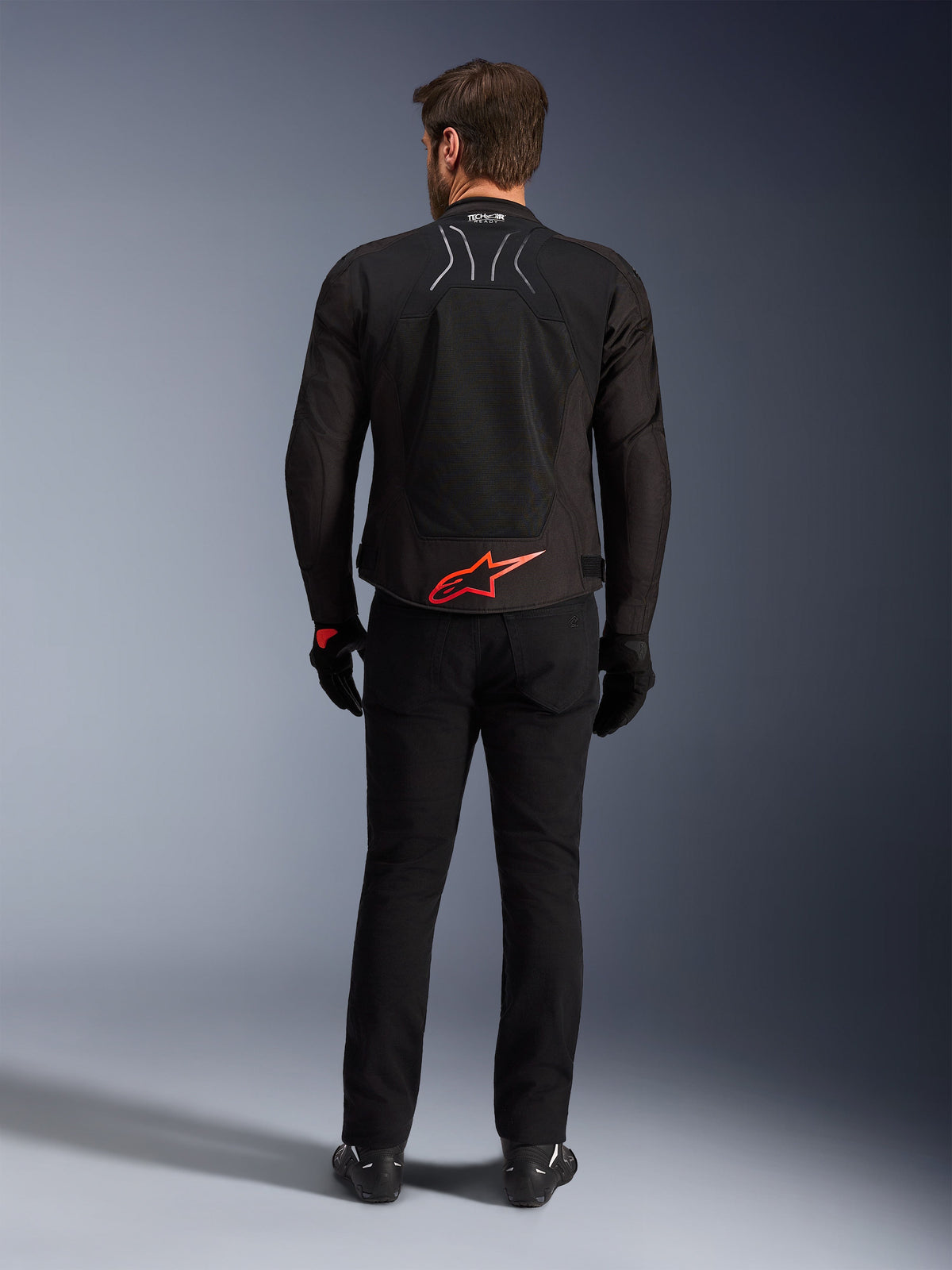 Alpinestars SMX Air Jacket, Black with Bright Red logo, Rear view showing Tech-Air Ready branding and mesh ventilation panels, worn with black pants and gloves, high-performance sport and racing motorcycle gear