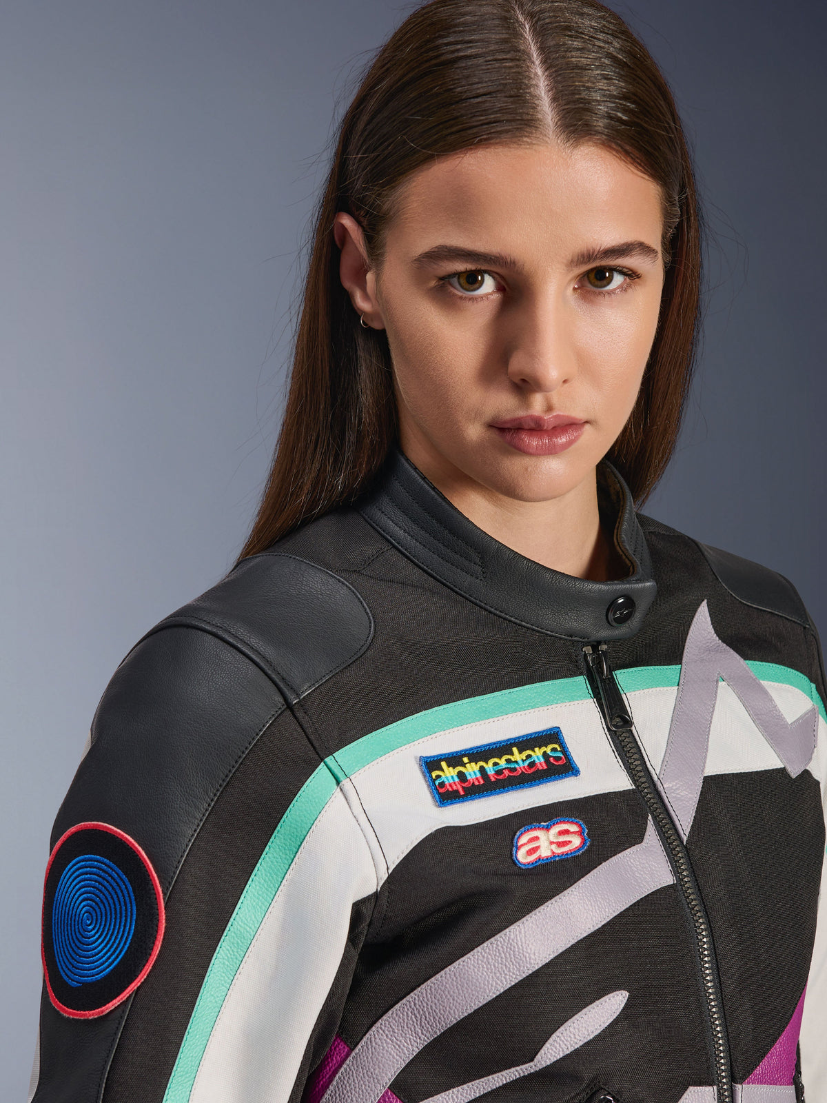 Alpinestars Idles Women's Jacket, Motorcycle Jacket, Black Off White and Purple with teal accents, close-up featuring colorful Alpinestars heritage patches and goat leather shoulder details, vintage-inspired design for urban riding.