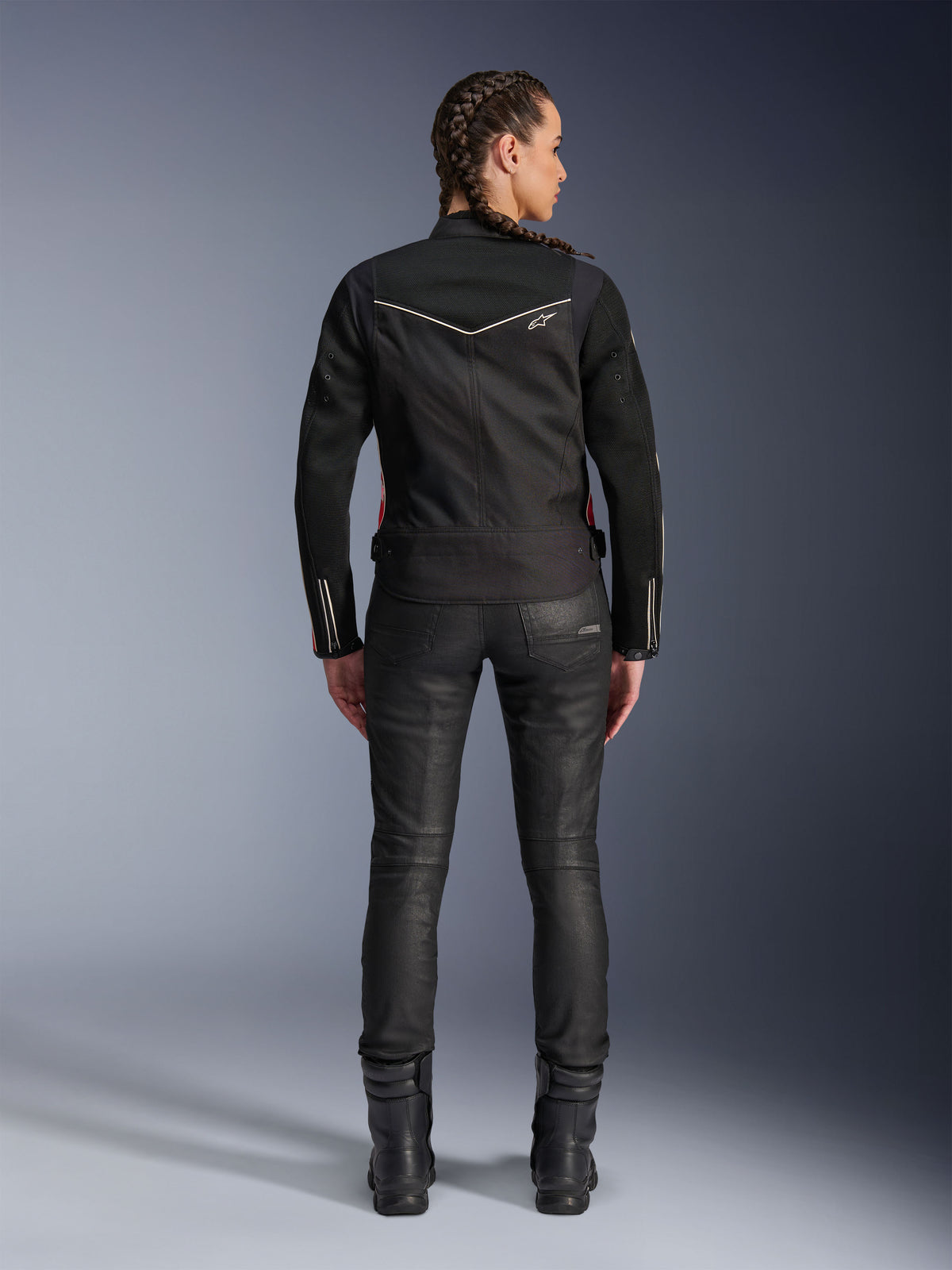 Alpinestars Stella T-Dyno Air jakke, set bagfra, sort motorcykeljakke til damer med hvide piping-detaljer og lille stjernelogo, båret med sorte tekniske bukser og kørestøvler, slank biker-pasform til urban kørsel