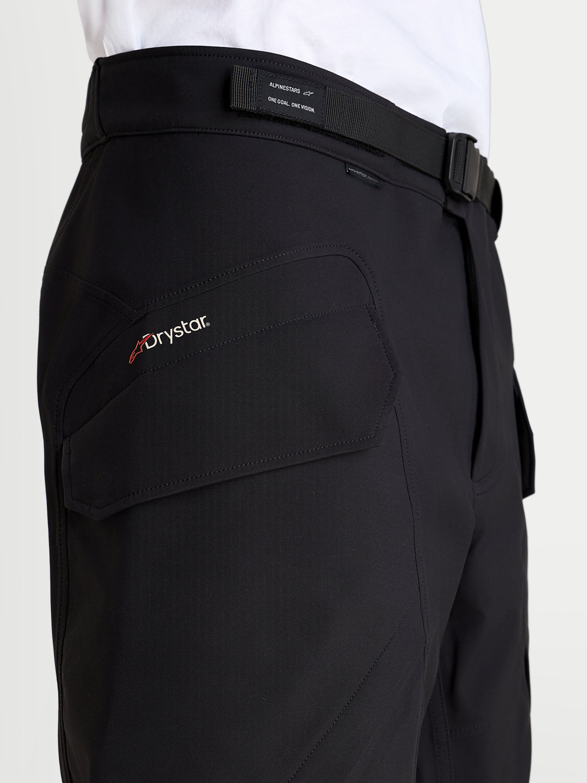 Alpinestars Juggernaut V2 Drystar Pants, men's urban waterproof motorcycle pants in black, close-up view highlighting the Drystar logo, cargo pocket, and adjustable magnetic buckle waistband