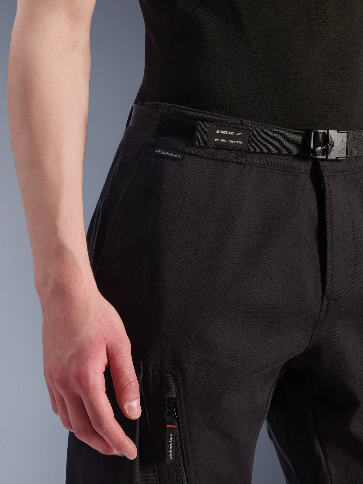 Alpinestars Flex-AST Cargo bukser, urbane motorcykelbukser, sort, nærbillede af talje og sidelomme, med integreret bælte med Alpinestars-branding, spændelukning og en lynlåslomme med mærket lynlåstrækker, teknisk tekstilkonstruktion til bykørsel