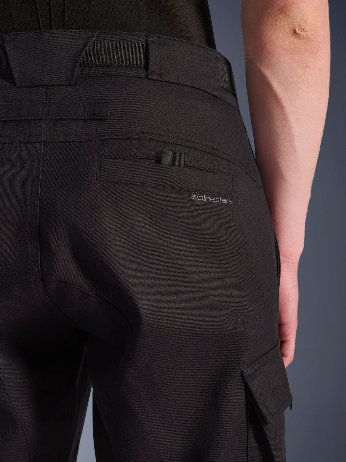 Nærbillede af Alpinestars Flex-AST Cargo Pants i sort, urbane motorcykelbukser med en detaljeret baglomme med diskret branding, store bæltestropper og en cargo-sidelomme i slidstærkt strækbart tekstil.