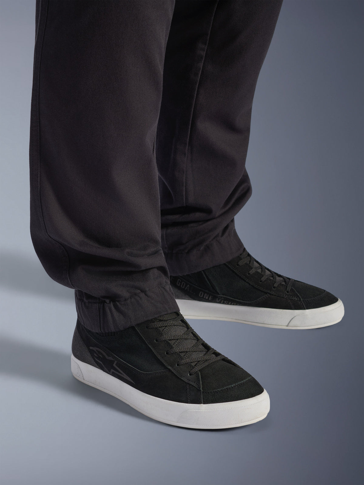 Alpinestars Flex-AST Cargo Pants - Short, urbane motorcykelbukser, sorte, med tilspidsede ben og elastiske sømme, kombineret med sorte Alpinestars sneakers, moderne urban kørestil