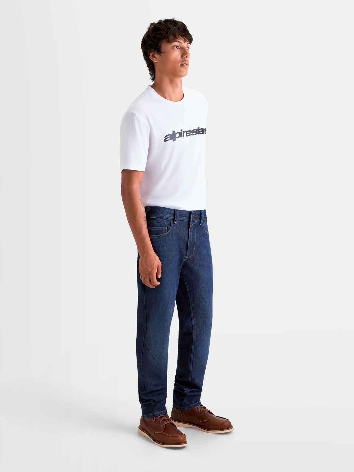 Alpinestars Flex-AST 7 Denim Pants Short, men's urban motorcycle riding jeans in dark blue, side profile view on a model wearing casual riding gear