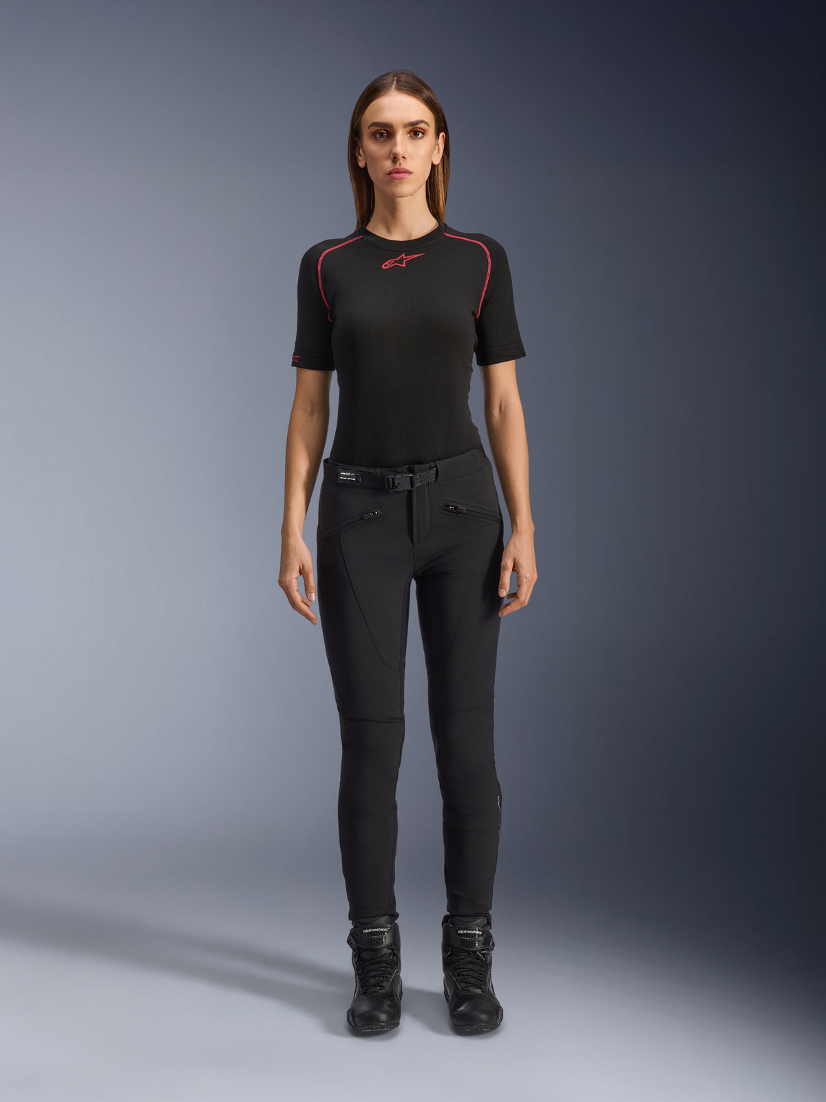 Alpinestars Alamosa damebukser, sorte motorcykelbukser i slim-fit, vist på en model set forfra, med lynlåslommer foran og integreret taljebælte, minimalistisk streetwear-inspireret stil til urban kørsel