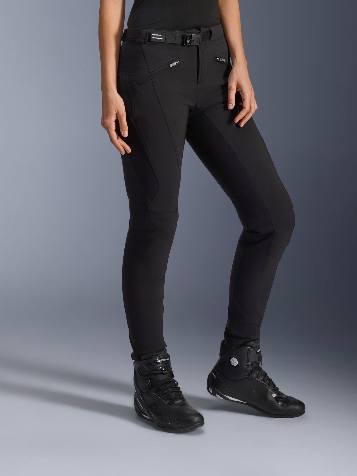 Alpinestars Alamosa Women Pants, Black Urban Motorcycle Pants, slim-fit design with zippered pockets and integrated waist belt, paired with black high-top riding shoes