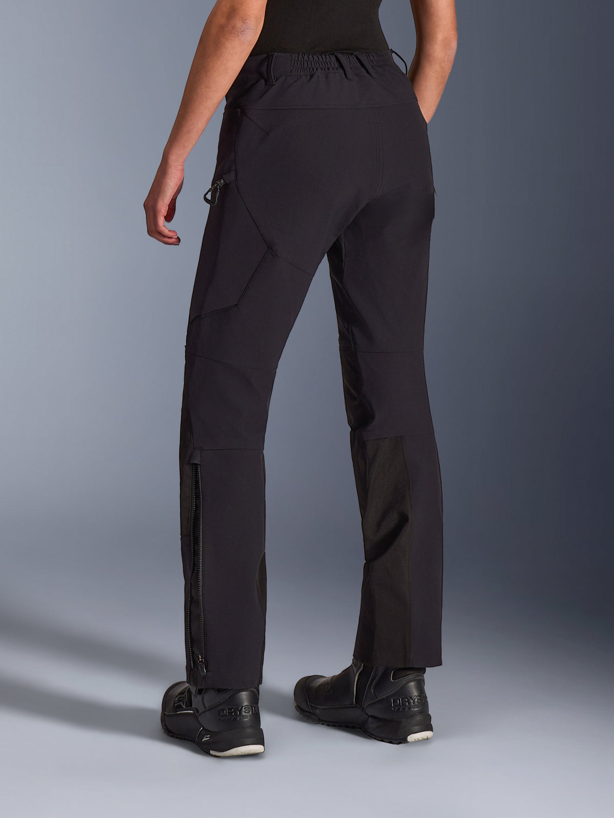 Alpinestars Stella Flex-AST Explorer Pants, Women's Motorcycle Pants, Black, rear view on model, featuring zippered lower leg hems and cargo pockets, lightweight stretch textile with ripstop reinforcements, paired with black riding boots