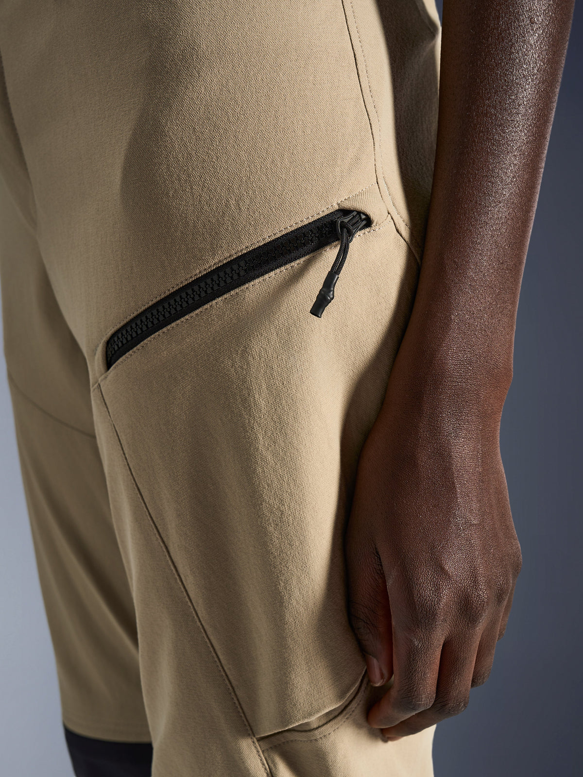 Alpinestars Woman Stella Flex-AST Explorer Pants in Sand, close-up of the hip and thigh area featuring a black diagonal zippered cargo pocket and durable ripstop textile fabric
