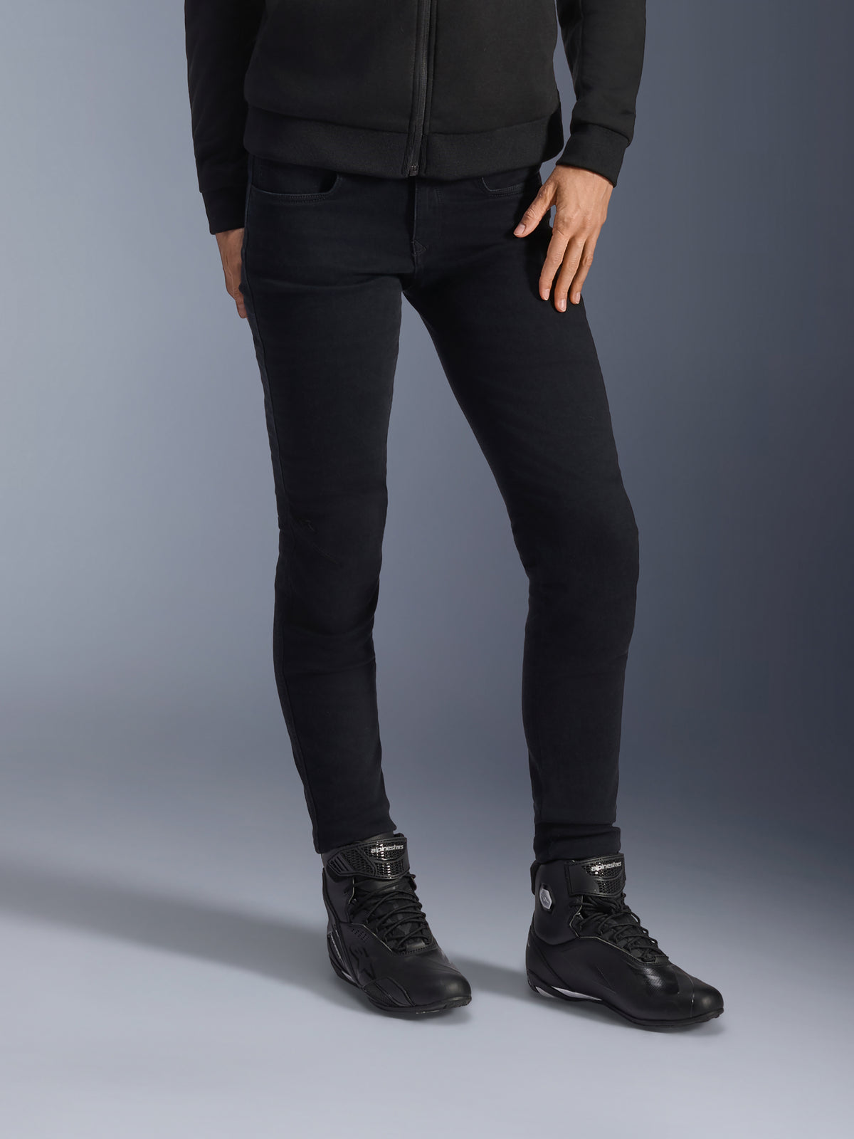 Alpinestars Daisy V3 motorcykeljeans til damer, Rinse Black, slim-fit motorcykeljeans, kombineret med sorte high-top ridestøvler og hættetrøje med lynlås, strømlinet monokrom urban styling
