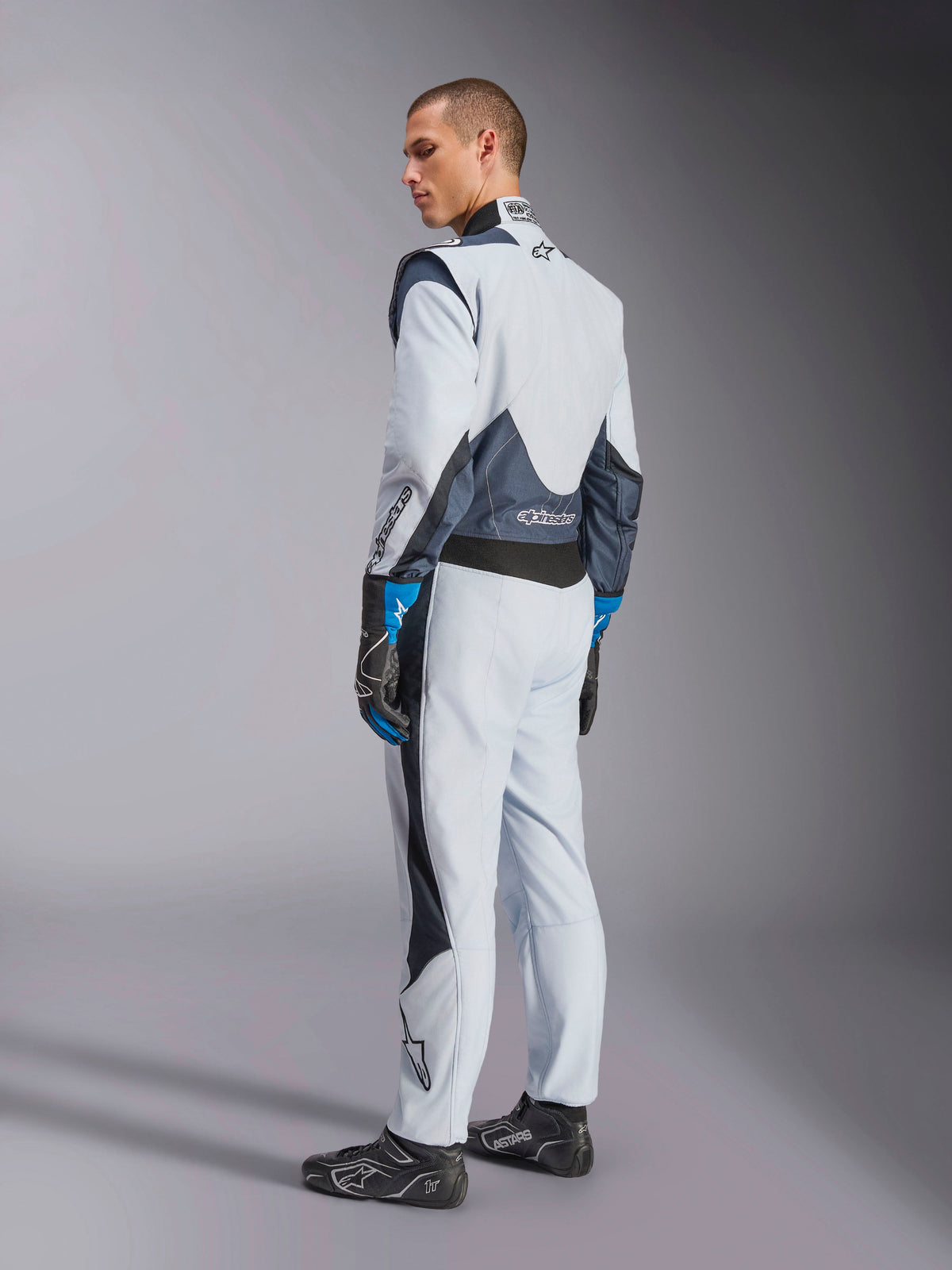 Alpinestars GP Pro Comp V2 FIA køredragt, herremodel til bilrace i sølv og blå med strækpaneler på ryggen.