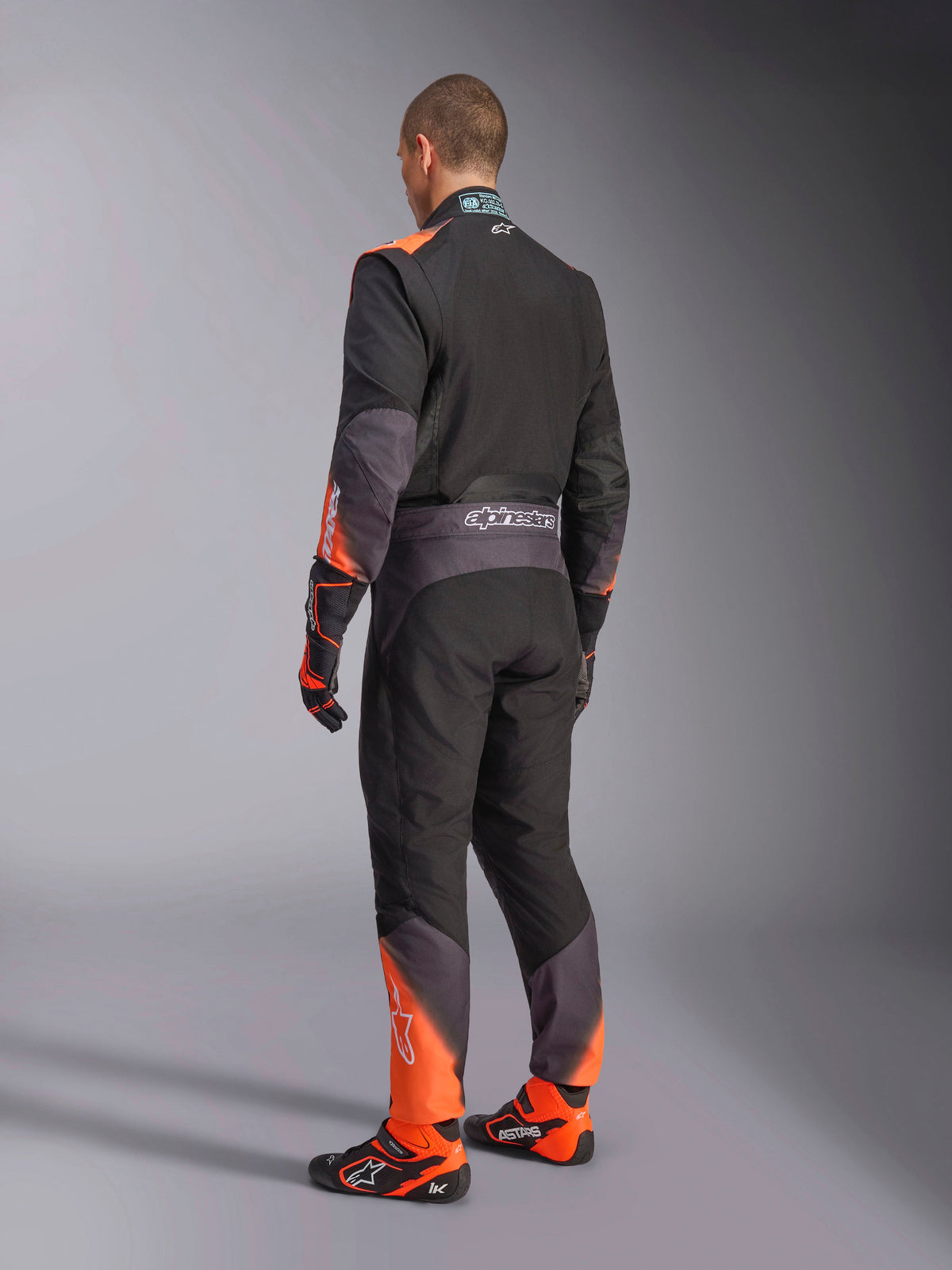 Alpinestars KMX-5 V3 karting køredragt til herrer, set bagfra i sort og orange fluo, FIA 8877-2022 Klasse 1.