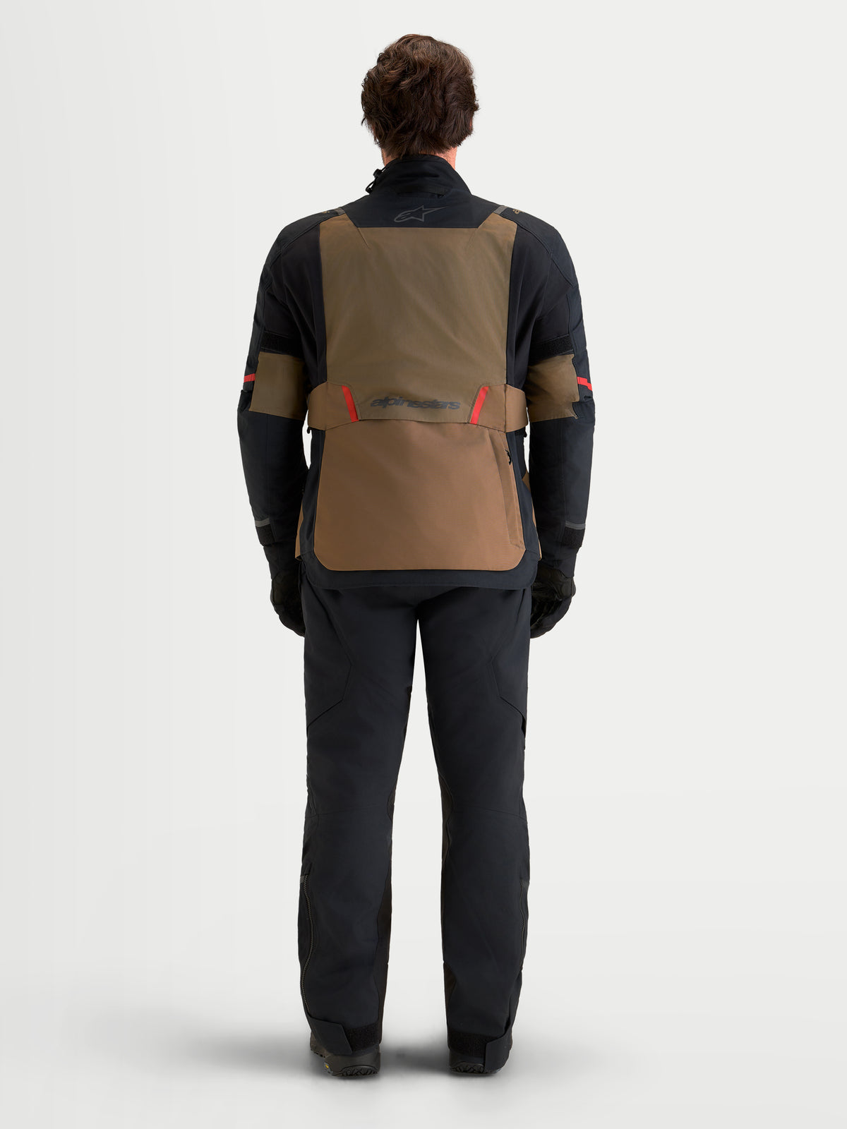 Alpinestars St-7 V2 2L Gore-Tex Gear Set, adventure touring motorcycle jacket and pants worn by a model, rear view in black and brown with red accents, waterproof textile construction