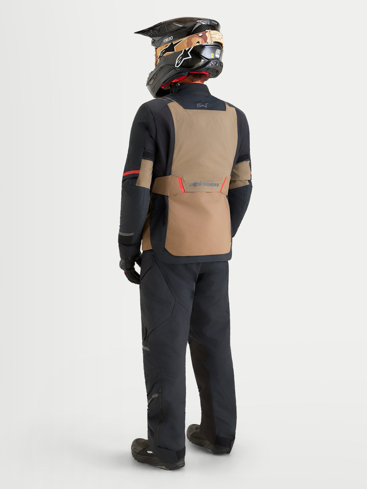 Alpinestars St-7 V2 2L Gore-Tex Gear Set, adventure touring motorcycle jacket and pants in black and khaki, rear profile view on a model wearing matching gear and helmet, waterproof textile construction.
