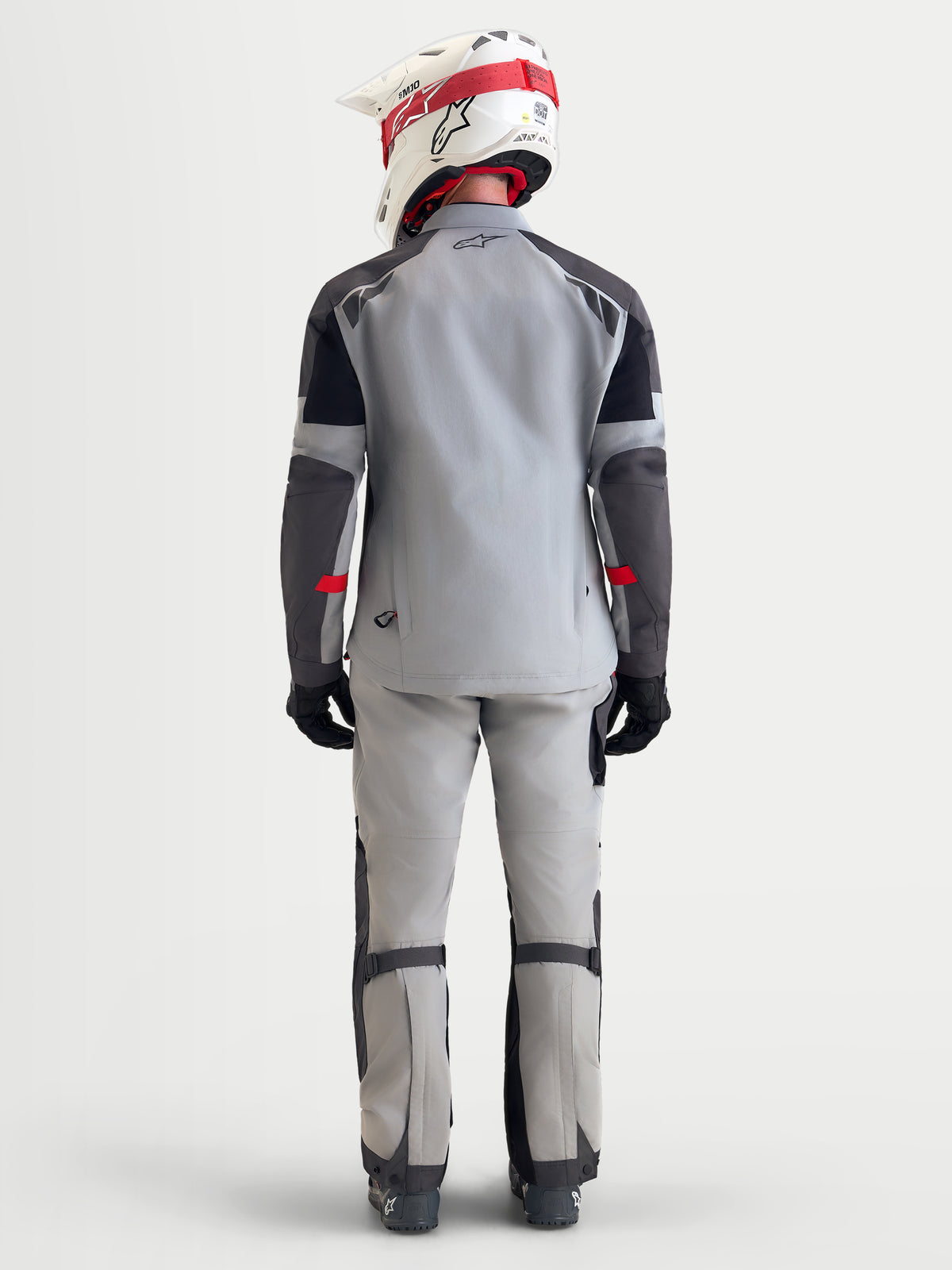 Alpinestars Arenis Gore-Tex udstyrssæt, herre adventure-motorcykeljakke og -bukser i lys grå, mørk grå og sort, set bagfra på model iført matchende hjelm og køresko