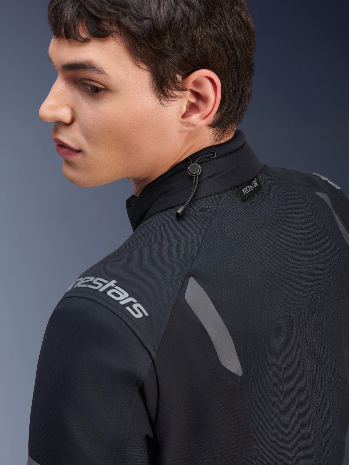 Alpinestars ST-7 2L GORE-TEX-jakke, sort og mørkegrå motorcykeljakke, nærbillede af kraven med stødledningsjustering og Tech-Air-mærke, grå reflekterende detaljer og logo på skulderen.