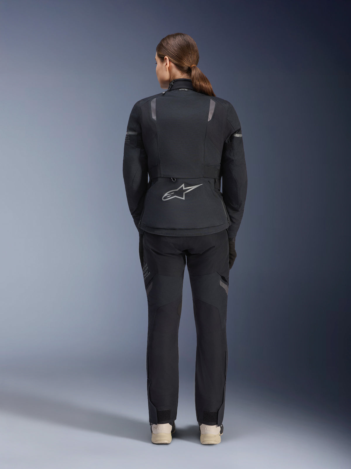Alpinestars Stella ST-7 2L GORE-TEX jakke og bukser, motorcykel adventure touring-sæt til kvinder, sort og mørkegrå, set bagfra med Astar-logo og refleksdetaljer, slidstærk vandtæt tekstilkonstruktion