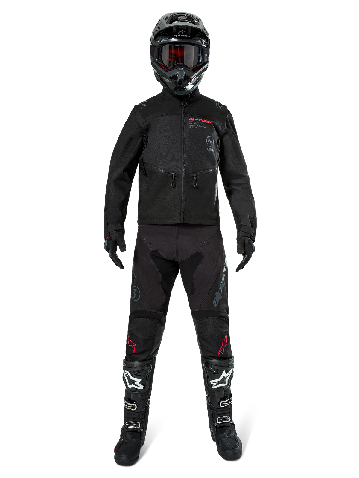 Alpinestars Pro-Dura jakke, sort off-road enduro-jakke, vist på en model med et komplet udstyrssæt inklusiv sort hjelm med røde goggles, sorte bukser med røde detaljer, sort-hvide støvler og sorte handsker, rally-inspireret robust design til terrænkørsel