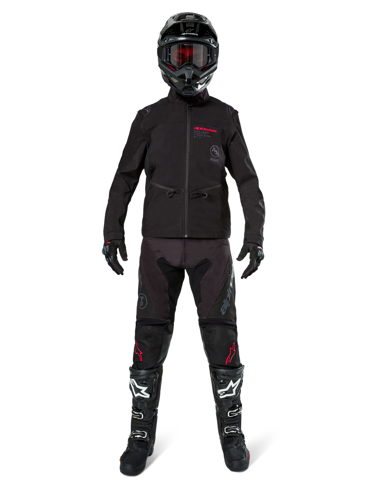 Motocross-kører iført Alpinestars Lite-Dura Softshell-jakke i sort med røde logodetaljer, kombineret med matchende sorte off-road bukser, sort hjelm og hvide og sorte støvler, komplet professionelt enduro-racerudstyr