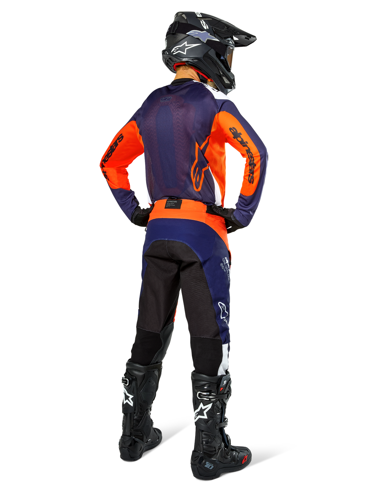 Alpinestars motocross-kører set bagfra, iført komplet racerudstyr, mørkeblå og orange jersey, Pro-Dura bukser i Navy Hot Orange White, sort hjelm og sorte støvler, professionelt terrænkørselsudstyr