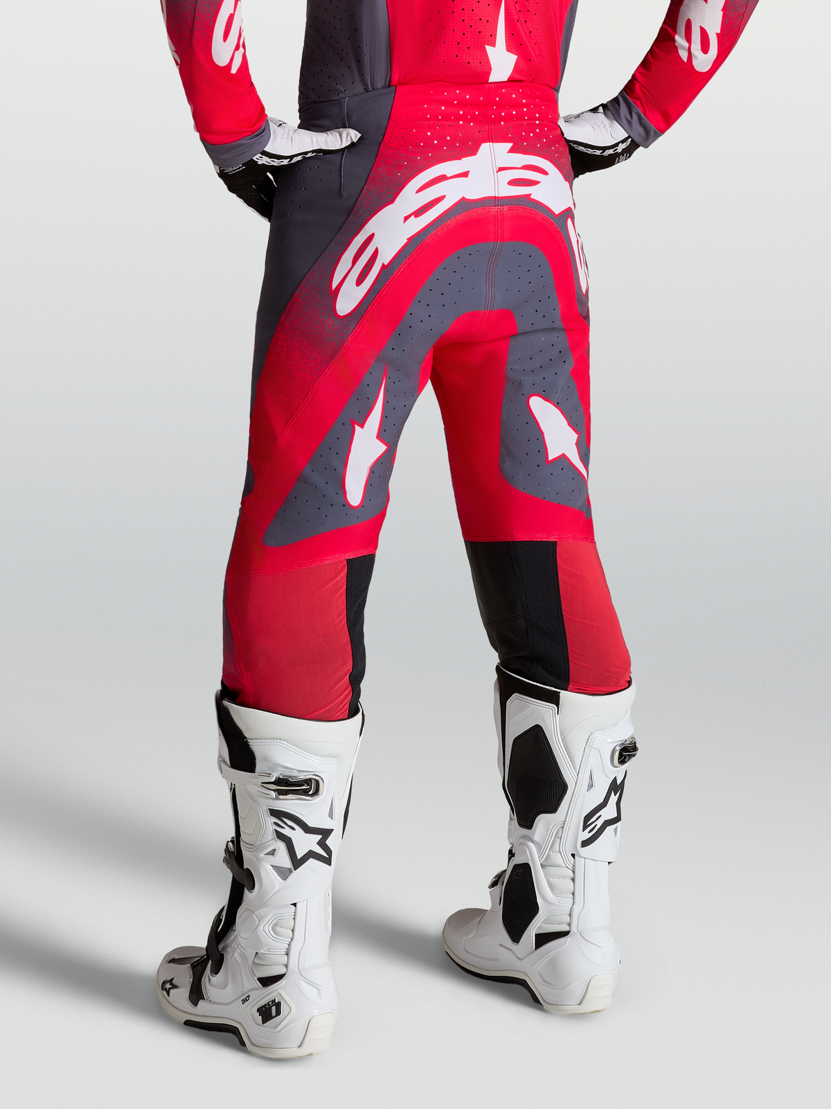 Alpinestars Supertech Hiten AFD bukser, røde og grå motocrossbukser, on-model bagfra med hvide racingstøvler.