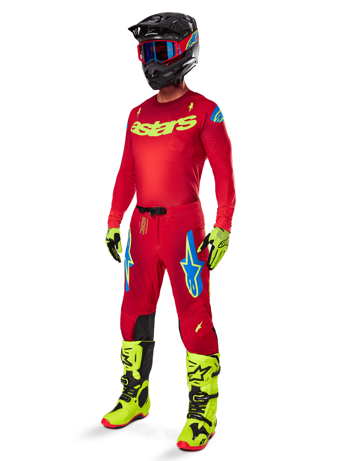 Motocross-rytter iført komplet Alpinestars racerudstyr, 2025 Supertech Maker bukser i Bright Red og Yellow Fluo, matchende rød trøje med neongult logo, neongule og sorte støvler, sort hjelm med blå briller, professionelt outfit til terrænkørsel