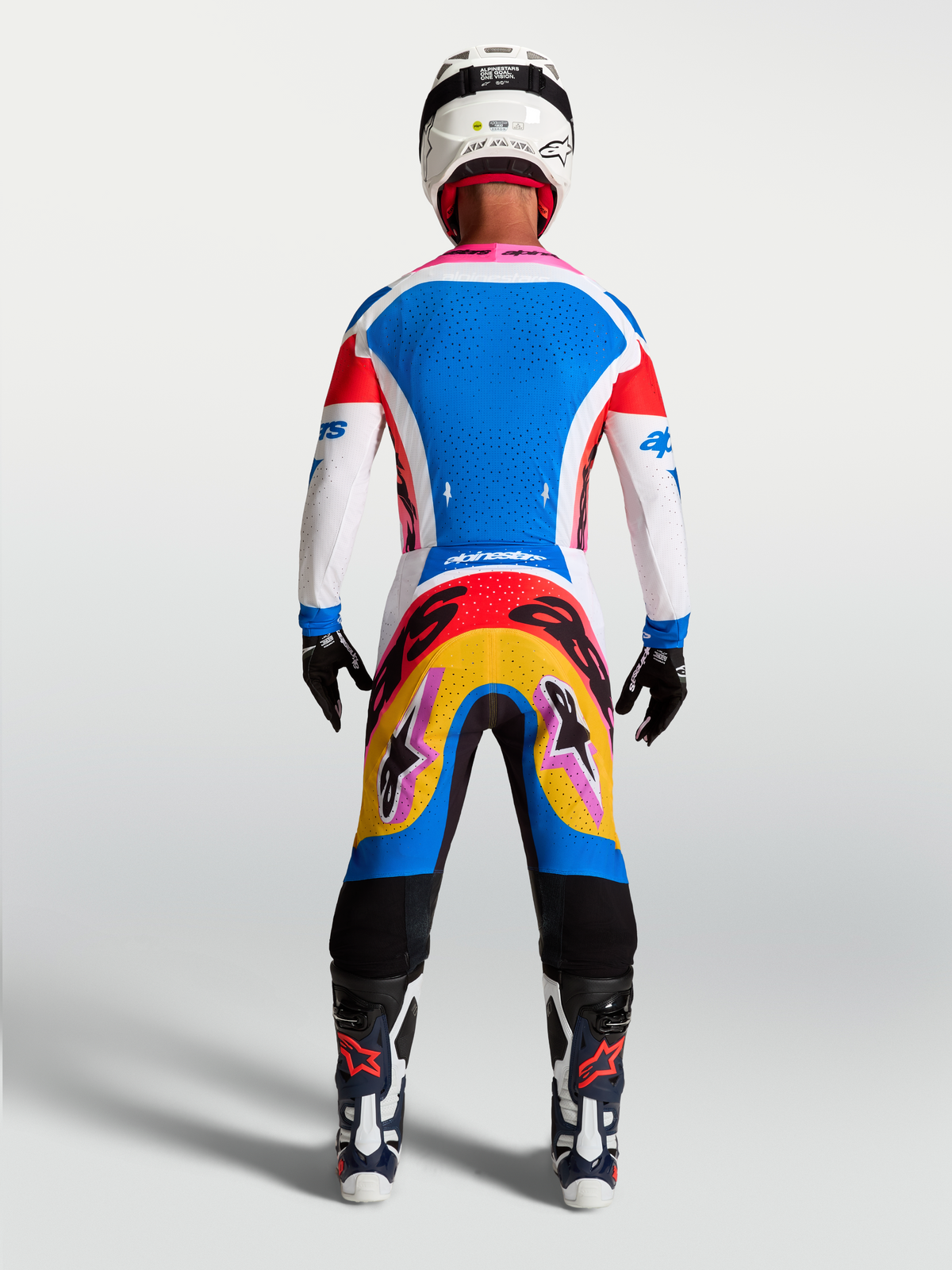 Alpinestars Supertech Dyna herre-motocrosssæt, blå og hvid trøje og bukser med farverig grafik, set bagfra på model.