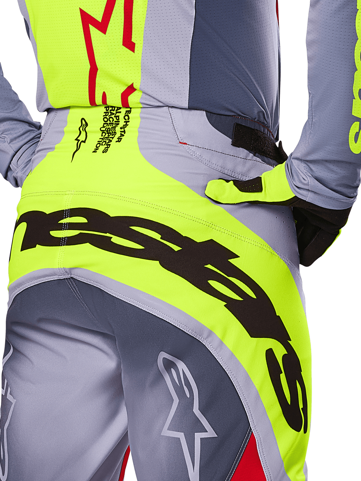 Alpinestars 2025 Techstar Melt bukser, nærbillede af bagdelen og taljeområdet, gråt og neongult design med stor sort branding, stjernelogoer og race-spec-tekst, højtydende motocross-udstyr