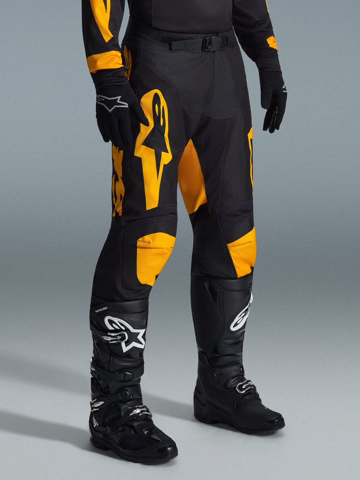 Alpinestars 2026 Racer Riway bukser, motocross-bukser, gul og sort, båret med sorte handsker og sorte motocross-støvler, med markant gul Alpinestars-branding og knædetaljer på en sort base, designet til højtydende off-road kørsel