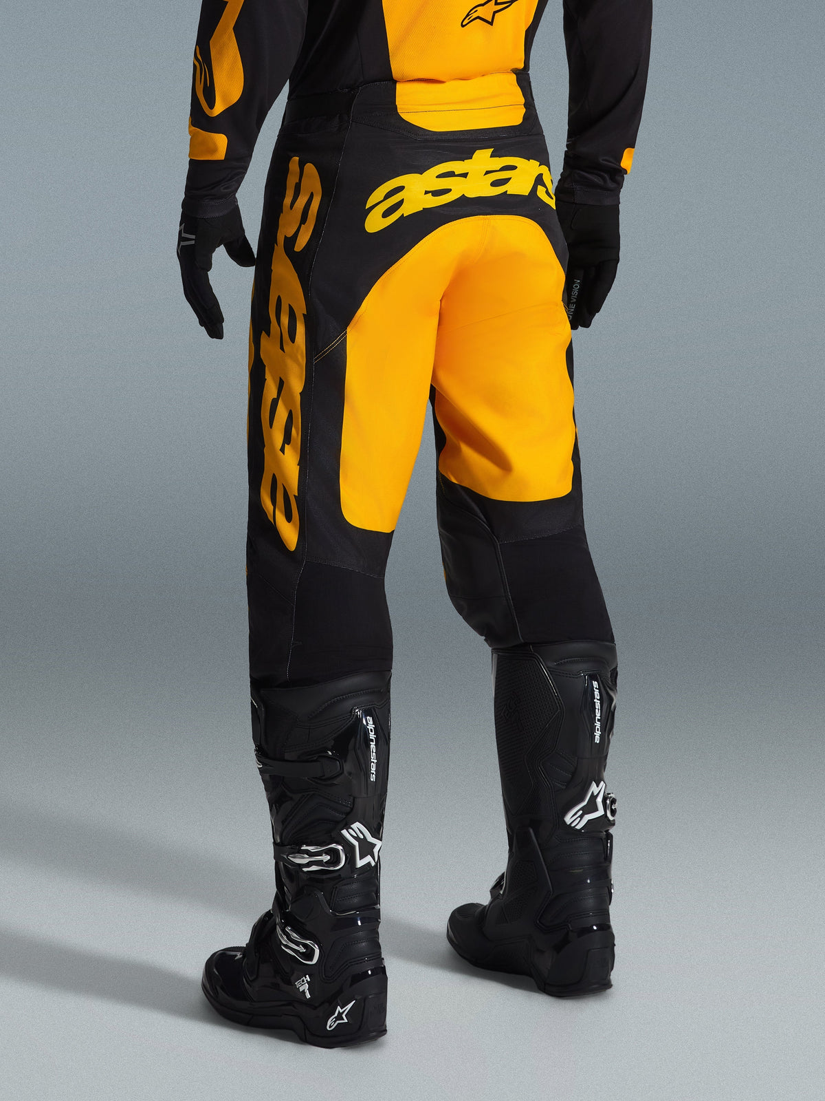 Alpinestars 2026 Racer Riway bukser, motocrossbukser, gul og sort, set bagfra med markant gult astars-branding over sædet og benet, kombineret med sorte motocross-støvler og handsker