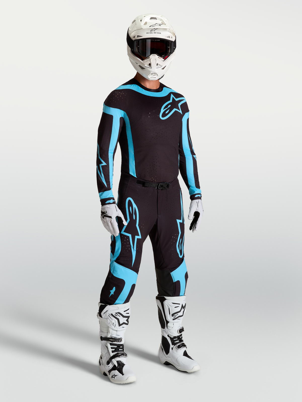 Alpinestars Supertech Vesta Pants, men's black and turquoise motocross racing gear with white boots and helmet.