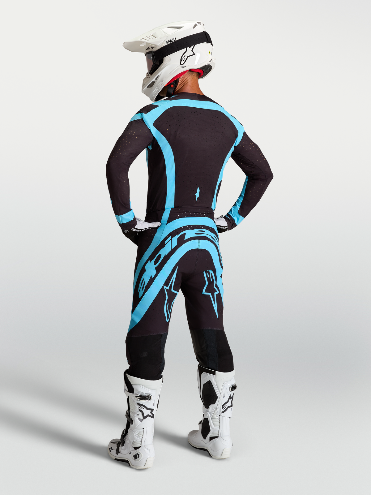 Alpinestars Supertech Vesta Pants, Black and Turquoise professional motocross gear shown from a rear view on model.