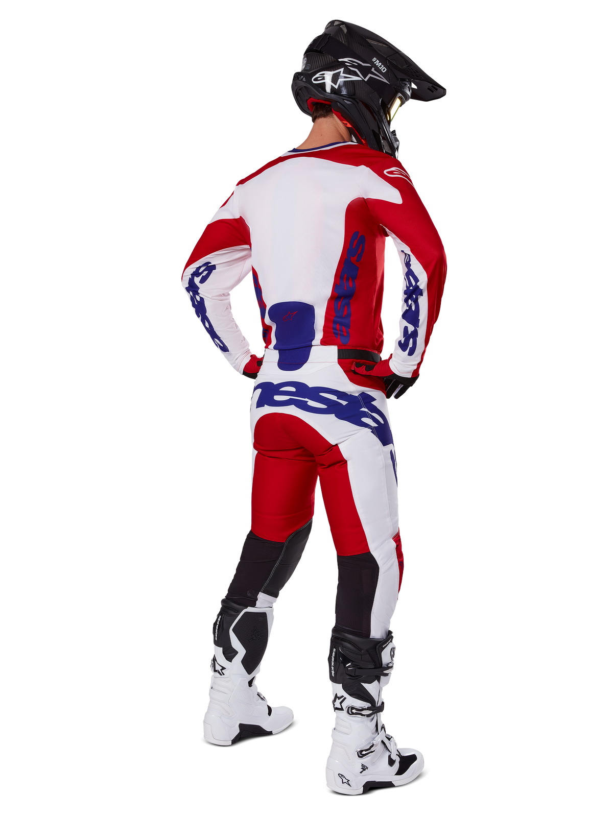 Alpinestars 2025 Racer Veil bukser, motocross-bukser, klar rød og hvid med blå detaljer, vist bagfra på en kører i fuldt udstyr, med markant Alpinestars-branding, åndbare paneler på underbenene samt koordinerede hvide støvler og sort hjelm.