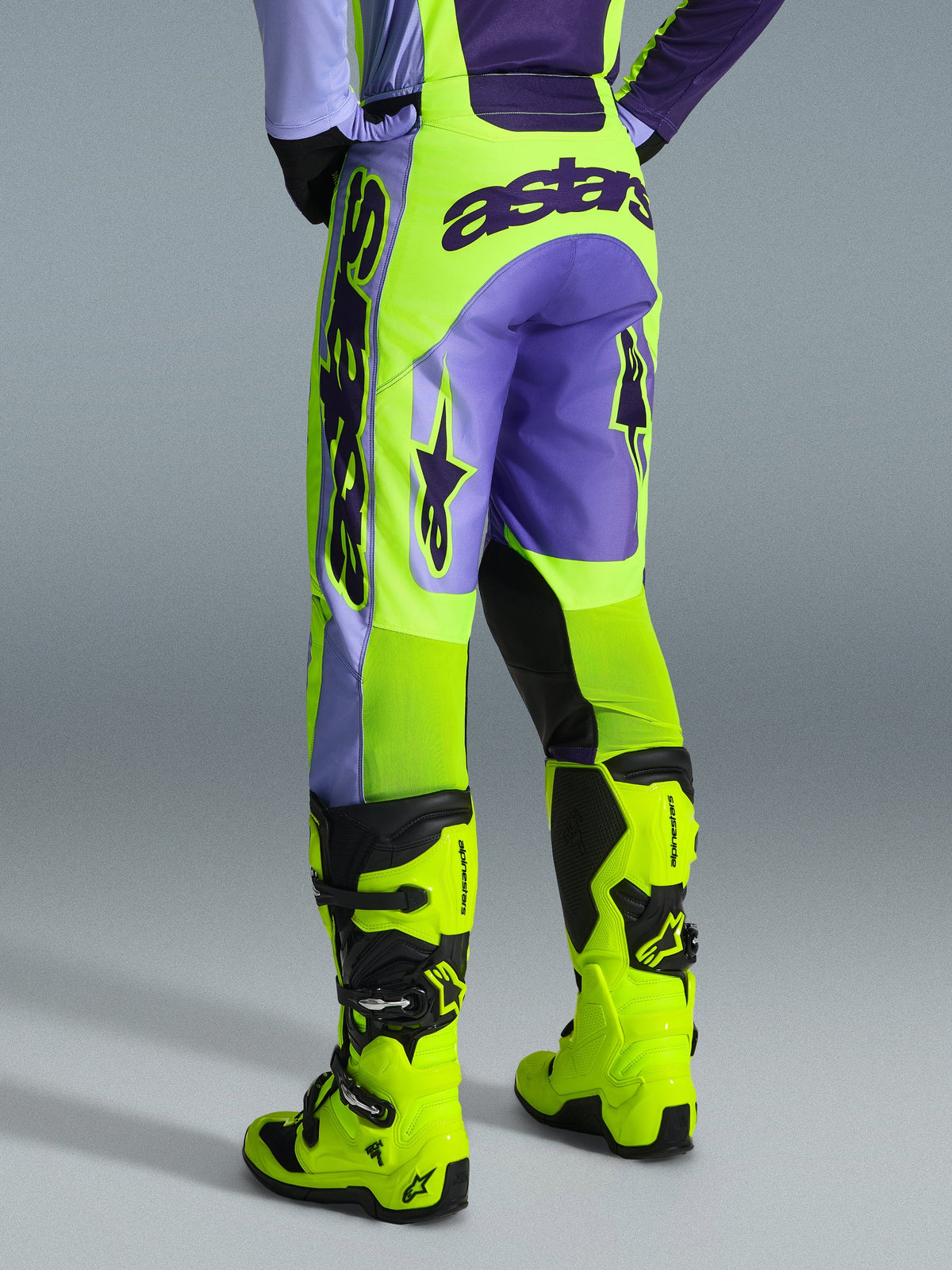 Alpinestars 2026 Racer Portl bukser, motocross-bukser, lilla og neongul, set bagfra med markant astars-branding og lilla detaljer, båret med matchende neongule motocross-støvler, slidstærkt syntetisk materiale til off-road racing