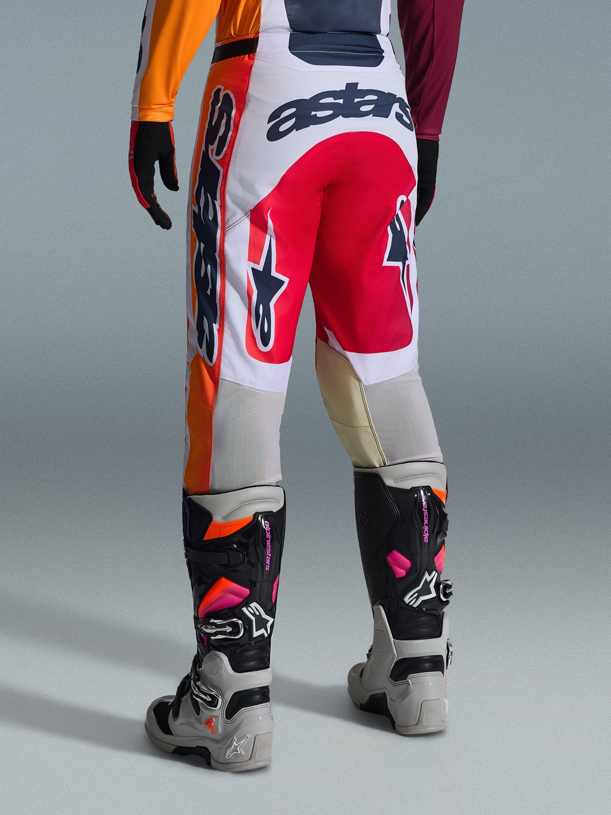 Alpinestars 2026 Racer Portl bukser, motocross-bukser, rød, lysegrå og mørkegrå, set bagfra med markant branding og logodetaljer, kombineret med matchende motocross-støvler og handsker, præstationsudstyr til off-road racing.