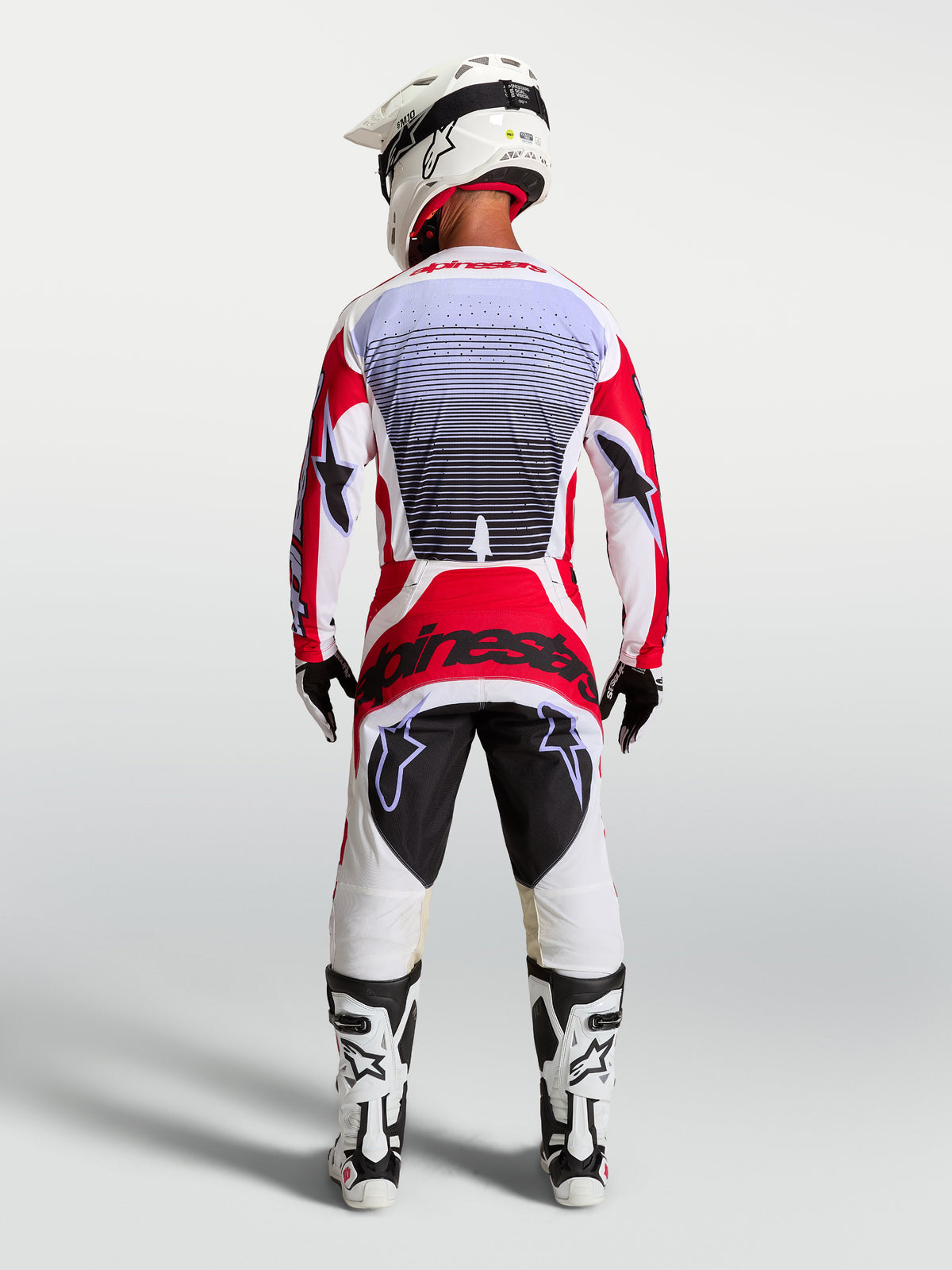 Alpinestars Techstar Maven motocrossbukser i rød og hvid, set bagfra på en rytter med atletisk racingpasform.