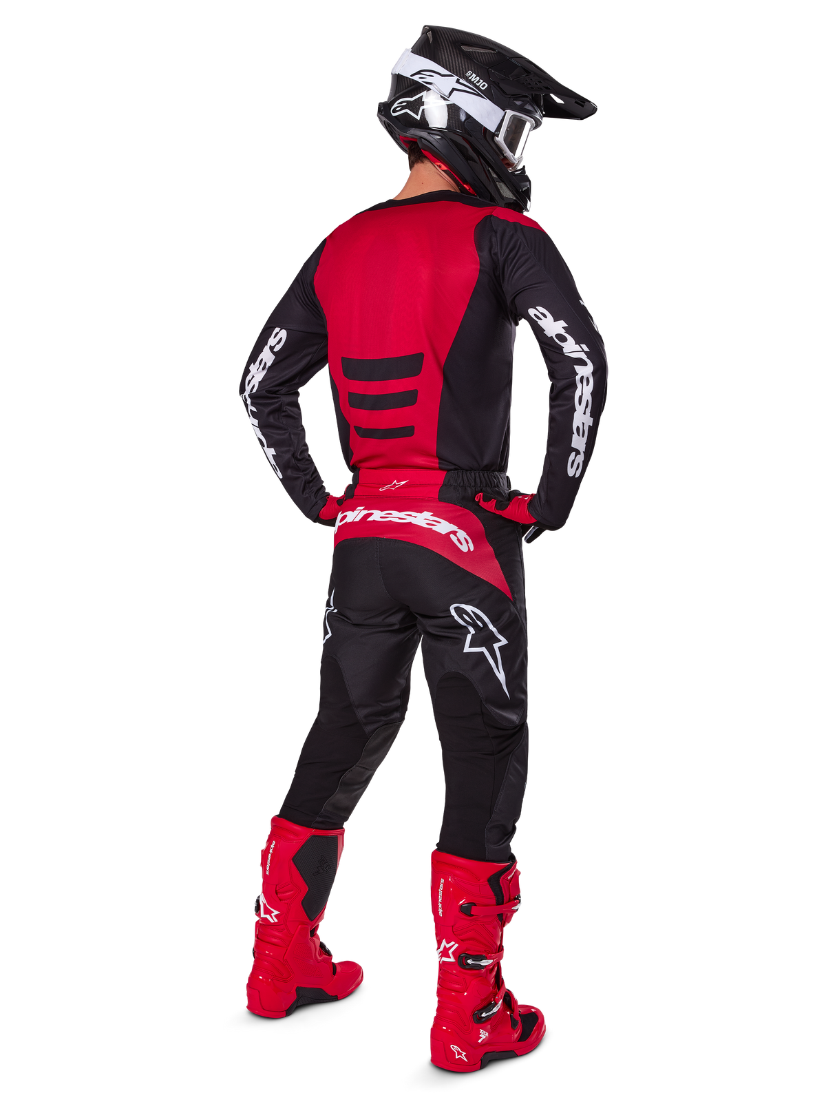 Motocrosskører iført Alpinestars 2025 Fluid Haul-udstyrssæt set bagfra, rød og sort trøje med hvid branding, matchende sorte bukser med røde detaljer, stærkt røde støvler og sort hjelm med hvide goggles, komplet koordineret outfit til off-road racing