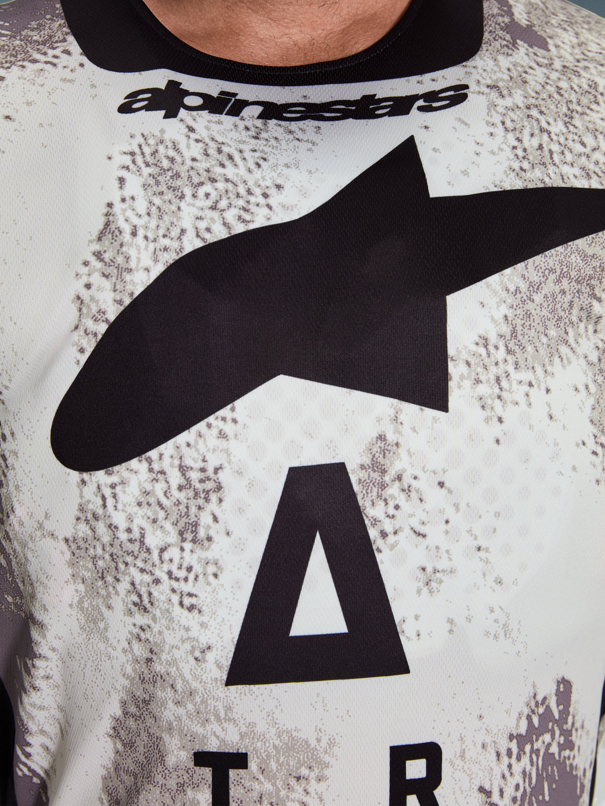 Alpinestars 2026 Racer Lahnd Jersey, Motocross Jersey, white and grey speckled pattern, close-up of chest with large black Astars logo and Alpinestars branding on the neckline, performance-oriented design for off-road riding