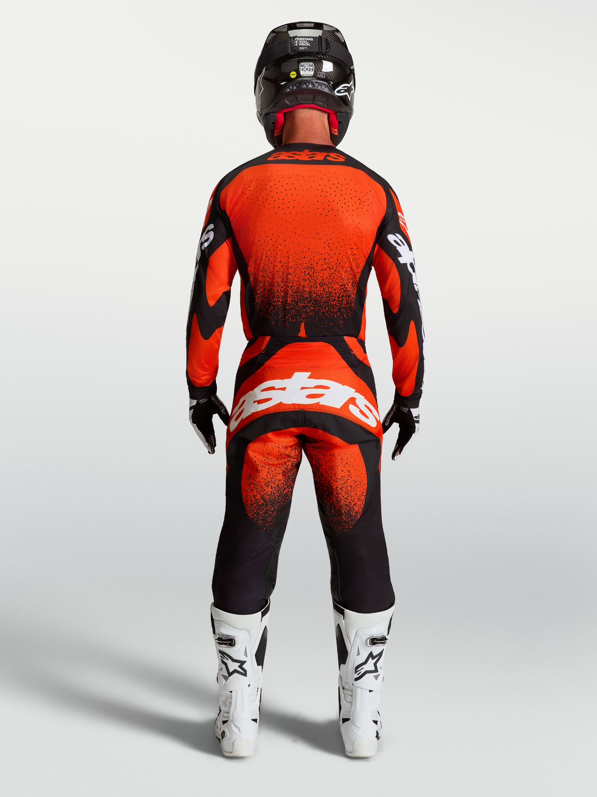Alpinestars Techstar Swan bukser, rød og sort motocrossudstyr til herrer, set bagfra med hvide racingstøvler.